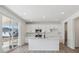 Bright kitchen featuring a center island, white cabinetry, and stainless steel appliances at 1324 Sienna Peak Cir, Erie, CO 80516