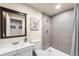 Modern bathroom featuring a shower with gray tiling and a sink with a large mirror at 2679 Leafdale Cir, Castle Rock, CO 80109