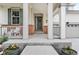 Front porch with white columns, space for seating, decorative plants, and a gray front door with wreath detail at 2679 Leafdale Cir, Castle Rock, CO 80109