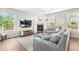 Bright living room with a fireplace, large TV, and lots of natural light from the large windows at 2679 Leafdale Cir, Castle Rock, CO 80109