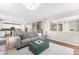 An open-concept living room featuring wood floors, a gray couch, and an attached kitchen with white cabinets at 2679 Leafdale Cir, Castle Rock, CO 80109