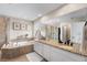 Spacious main bathroom featuring double vanity, large mirror, soaking tub, and glass shower at 2679 Leafdale Cir, Castle Rock, CO 80109