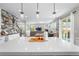 Open floor plan with a kitchen island, dining area, and wet bar, with hardwood flooring and modern finishes at 2679 Leafdale Cir, Castle Rock, CO 80109
