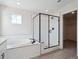 Bathroom featuring a tub and black-framed glass shower with tile surround at 4741 Twelve Oaks Way, Castle Rock, CO 80104