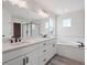 Large bathroom with a double vanity, shower, and soaking tub with black hardware at 4741 Twelve Oaks Way, Castle Rock, CO 80104