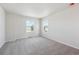 Bright bedroom featuring neutral carpet, white walls, and natural light from two windows at 841 Alpine Ridge St, Erie, CO 80516