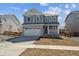 Charming two-story home with a gray exterior, stone accents, an attached two-car garage, and a well-manicured lawn at 841 Alpine Ridge St, Erie, CO 80516