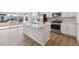 Bright kitchen featuring stainless steel appliances, a spacious island, white cabinetry, and an adjacent sliding glass door at 841 Alpine Ridge St, Erie, CO 80516
