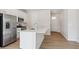 Modern kitchen with white cabinets, stainless steel appliances, an island with quartz countertop, and wood-look floors at 841 Alpine Ridge St, Erie, CO 80516