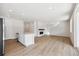Open-concept living space with sleek fireplace, hardwood floors, and kitchen in background featuring stainless appliances at 841 Alpine Ridge St, Erie, CO 80516