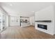 Spacious open-concept living space with sleek fireplace, hardwood floors, kitchen, and access to patio via sliding doors at 841 Alpine Ridge St, Erie, CO 80516