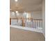 Bright hallway with carpet and wood railing, leading to additional rooms and upper floors at 21286 E Nassau Ave, Aurora, CO 80013