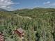 An aerial view of a brown roof home, surrounded by a lush green forest at 10438 Sunlight Ln, Conifer, CO 80433