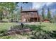 Landscaped backyard featuring a deck with stairs and a manicured garden, perfect for outdoor living at 10438 Sunlight Ln, Conifer, CO 80433