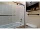 Well-lit bathroom featuring a shower over tub, storage cabinet, and ceramic tile at 10438 Sunlight Ln, Conifer, CO 80433