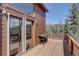 Exterior deck with wood railing and sliding door, providing access to scenic views at 10438 Sunlight Ln, Conifer, CO 80433