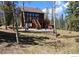 Charming cabin with a deck and stairs amongst birch trees, perfect for mountain living and entertaining at 10438 Sunlight Ln, Conifer, CO 80433