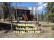 Charming cabin with a deck and stairs amongst birch trees, perfect for mountain living and entertaining at 10438 Sunlight Ln, Conifer, CO 80433