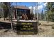 Charming two-story cabin home with natural landscaping and open house invitation at 10438 Sunlight Ln, Conifer, CO 80433