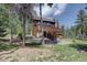 Exterior of this beautiful home featuring a wooden deck, lawn, and lots of trees at 10438 Sunlight Ln, Conifer, CO 80433