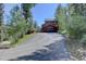 Charming mountain home with an attached garage and driveway, surrounded by lush greenery and natural beauty at 10438 Sunlight Ln, Conifer, CO 80433