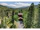 Secluded cabin-style home nestled amongst towering trees with a driveway, promising privacy and scenic views at 10438 Sunlight Ln, Conifer, CO 80433