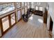 Spacious living room with hardwood floors, a stone fireplace, lots of windows, and sliding door access to a balcony at 10438 Sunlight Ln, Conifer, CO 80433