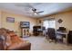 Spacious living room offers a comfortable leather sofa, a ceiling fan, and dedicated workspaces with multiple monitors at 10438 Sunlight Ln, Conifer, CO 80433