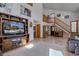 Spacious living room featuring a staircase, wood floors, and an entertainment center, perfect for relaxing and entertaining at 10438 Sunlight Ln, Conifer, CO 80433