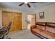 Cozy living room with a comfortable brown leather couch, ceiling fan, and a view into the hall at 10438 Sunlight Ln, Conifer, CO 80433