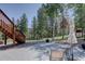 An outdoor patio with a table and umbrella nestled among trees at 10438 Sunlight Ln, Conifer, CO 80433