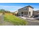 Exterior view showcasing the back of the home with a hot tub, covered porch, and spacious lawn at 16062 Red Bud Loop, Parker, CO 80134