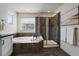 Modern bathroom showcasing a soaking tub with wood trim, a glass shower, and tile flooring at 16062 Red Bud Loop, Parker, CO 80134