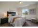 Comfortable bedroom with a large window, plush bedding, and stylish nightstands for a relaxing retreat at 16062 Red Bud Loop, Parker, CO 80134