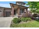 Charming front porch shows brick columns, a cozy seating area, and manicured landscaping at 16062 Red Bud Loop, Parker, CO 80134