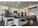 Bright kitchen boasts white cabinetry, a central island with bar seating, and modern stainless steel appliances at 16062 Red Bud Loop, Parker, CO 80134