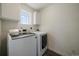 Bright laundry room features a modern washer and dryer set, window, and white cabinets at 16062 Red Bud Loop, Parker, CO 80134