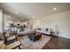 Open-concept living room features hardwood floors, neutral furniture, and seamless transition to the modern kitchen at 16062 Red Bud Loop, Parker, CO 80134