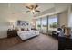 Spacious main bedroom featuring a tray ceiling, ceiling fan, large windows, and stylish furnishings at 16062 Red Bud Loop, Parker, CO 80134
