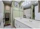 Green bathroom with a double sink vanity, large mirror, and neutral colored tile flooring at 6930 S Broadway, Centennial, CO 80122