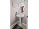 Stylish powder room featuring a pedestal sink and soft pink walls at 6930 S Broadway, Centennial, CO 80122