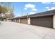 Row of garages, each with paneled doors, attached to townhomes on a concrete driveway under blue sky at 6930 S Broadway, Centennial, CO 80122