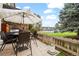 Outdoor patio with a gas grill, dining table, patio umbrella, and a lush green lawn at 6930 S Broadway, Centennial, CO 80122