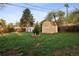 Large backyard featuring a shed, mature trees, and green grass for outdoor enjoyment at 6390 W 47Th Ave, Wheat Ridge, CO 80033