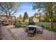Spacious backyard with a patio area featuring an outdoor dining set, grill, and manicured lawn at 6390 W 47Th Ave, Wheat Ridge, CO 80033