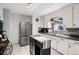 Efficient kitchen features stainless steel appliances, white cabinets, and tile floor at 6390 W 47Th Ave, Wheat Ridge, CO 80033
