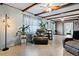 Bright and airy living room boasts wood-beamed ceilings and comfortable seating arrangement with wood floors at 6390 W 47Th Ave, Wheat Ridge, CO 80033