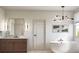 Elegant bathroom with a freestanding tub, wood vanity, and modern lighting at 2778 Utica St, Denver, CO 80212