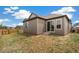 Backyard exterior shows siding, sliding glass door, small patio, and new landscaping at 9313 Biscay St, Commerce City, CO 80022