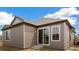 Back exterior of home shows the siding, windows, sliding glass door, and landscaping at 9313 Biscay St, Commerce City, CO 80022